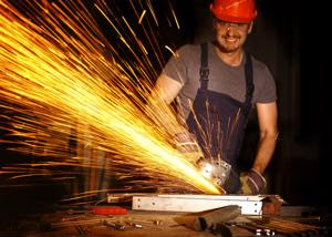 A worker grinds metal.