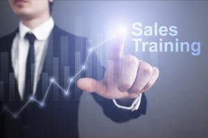A businessman pointing to a "sales training" graphic.