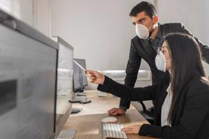 Workers wearing respiratory masks in the office.