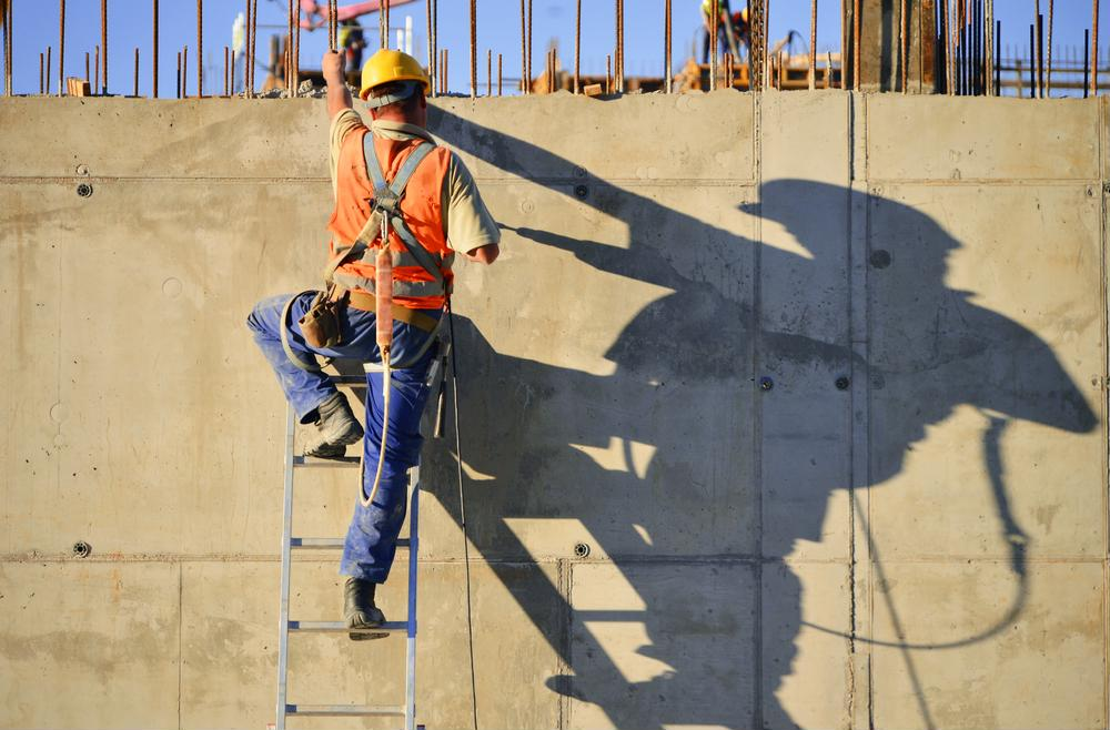 man in construction gear climbing a ladder